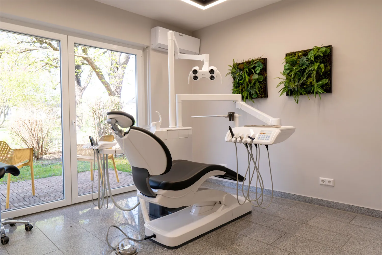 Behandlungszimmer mit Behandlungsstuhl und Fenster zum Garten