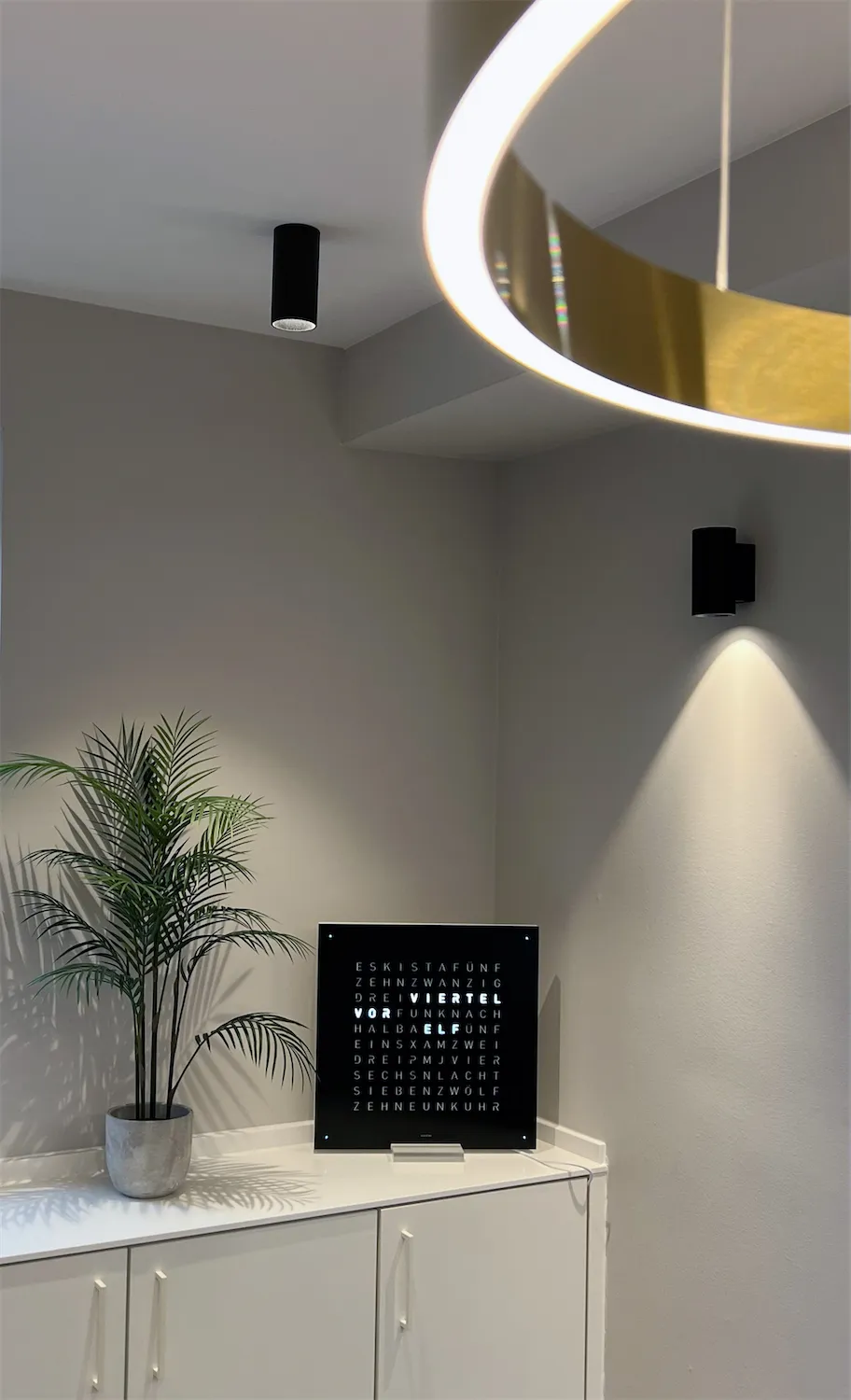 Ecke mit Pflanze, Wandleuchte und Wanddekoration